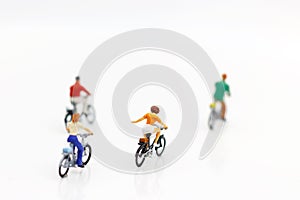 Miniature people enjoy riding a bicycle on white background