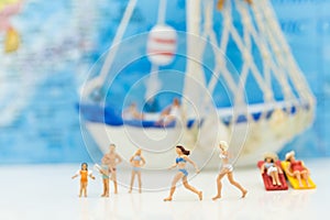 Miniature people : Families running on the beach happily. Have a boat as a backdrop, used as a business travel concept