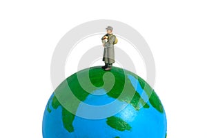 Miniature people figure toy conceptual photography. Global news delivery service A military mail officer holding news pack