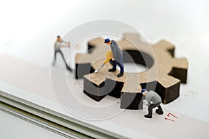 Miniature people with gear cog symbol on calendar, Business management and working process concept