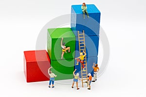 Miniature people : Group Athletes use stairs to climb colorful wood building. Image use for Activities, travel, business concept