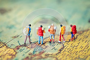 Miniature people: Group of backpacker on vintage world map