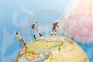 Miniature people: Group traveler backpack stand and walking on world map. Image use for travelling or business trip concept photo