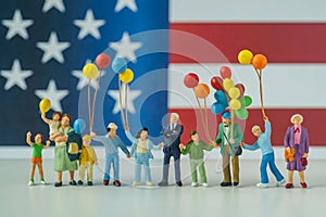 Miniature people, happy american family holding balloon with Uni