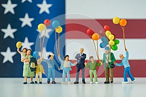 Miniature people, happy american family holding balloon with Uni