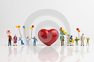 Miniature people happy love family holding balloons with red hea