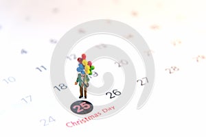 Miniature people holding balloon stand on the calenda,