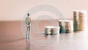 Miniature people looking future with stack coin about financial