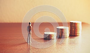 Miniature people looking future with stack coin about financial