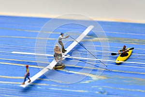 Miniature people : man fishing on a lake from the boat