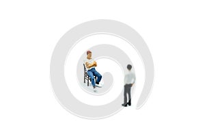 Miniature people : Man sitting a chair with businessman.