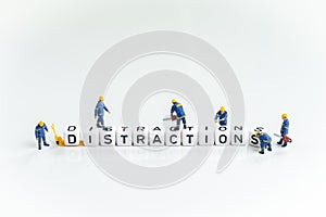 Miniature people man working on cube small block building the word Distractions on solid white background using as eliminate