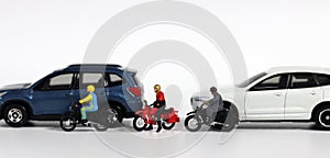 Miniature people and miniature car. Miniature motorcycle messenger between miniature cars.