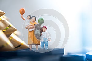 Miniature people: mom and son holding balloon
