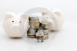 Miniature people, Old couple figure sitting on top of stack coins using as background retirement planning, Life insurance concept.