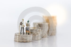 Miniature people: Old people standing on top of stack coins . Image use for background retirement planning, Life insurance concept