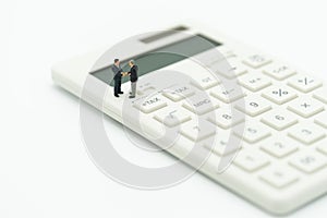 Miniature people Pay queue Annual income TAX for the year on calculator. using as background business concept and finance