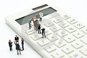 Miniature people Pay queue Annual income TAX for the year on calculator. using as background business concept and finance