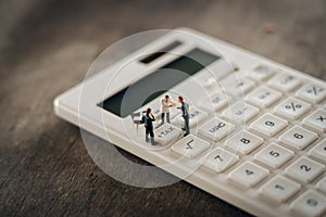 Miniature people Pay queue Annual income TAX for the year on calculator. using as background business concept and finance