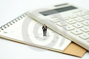 Miniature people Pay queue Annual income TAX for the year on calculator. using as background business concept and finance