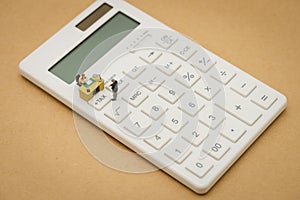 Miniature people Pay queue Annual income TAX for the year on calculator. using as background business concept and finance