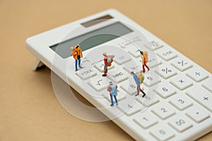 Miniature people Pay queue Annual income TAX for the year on calculator. using as background business concept and finance