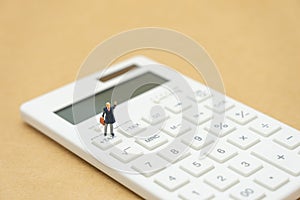 Miniature people Pay queue Annual income TAX for the year on calculator. using as background business concept and finance