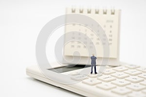 Miniature people Pay queue Annual income TAX for the year on calculator. using as background business concept and finance