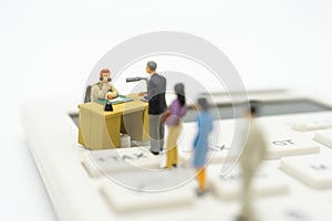 Miniature people Pay queue Annual income TAX for the year on calculator. using as background business concept and finance