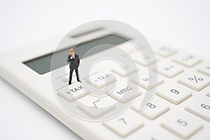 Miniature people Pay queue Annual income TAX for the year on calculator. using as background business concept and finance