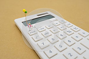 Miniature people Pay queue Annual income TAX for the year on calculator. using as background business concept and finance