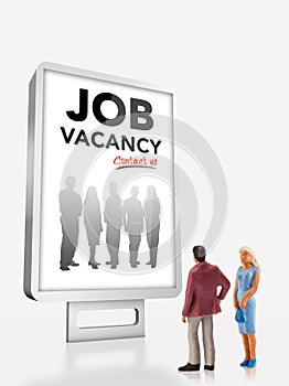 Miniature people - people standing in front of a job recruitment billboard