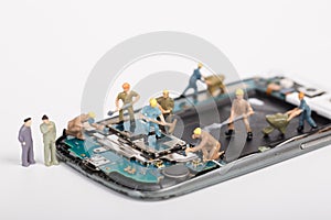 The miniature people repair smartphone