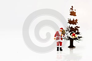 Miniature people: Santa Claus whit Christmas Tree.