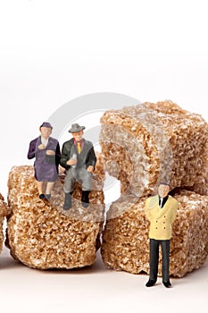 Miniature people: seniors, in front, cubes of brown sugar.