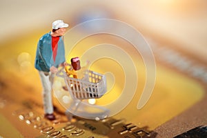 Miniature people: shopper walking on credit card as payment and purchase online e-commerce and shopping concept