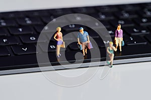 miniature people with shopping bags on a computer keyboard