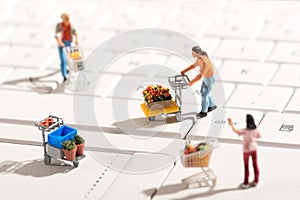 Miniature people shopping for items with carts