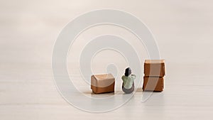 A miniature people sitting in a pile of cardboard boxes.