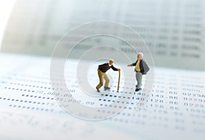 Miniature people stand on the bank passbook, Retirement planning and life insurance concepts