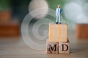 Miniature people stand on cube block on with word MD : Managing director