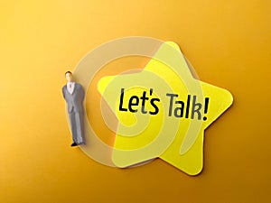Miniature people and sticky note with the word Let's Talk