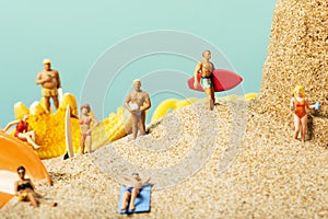 Miniature people in swimsuit on the beach