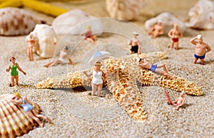 Miniature people in swimsuit on the beach