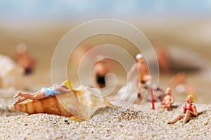 Miniature people in swimsuit on the beach