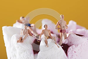 Miniature people in swimsuit on an ice cream