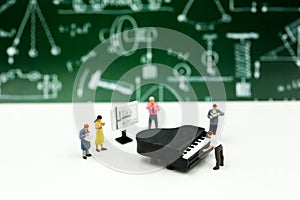 Miniature people : Teacher and student with piano class of music