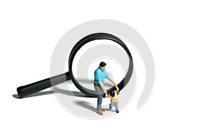 Miniature people toy figure photography. Exploring and play together. A father and son walking in front of magnifier glass.