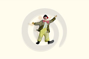 Miniature people toy figure photography. Full body of a clown wearing huge bowties standing on yellow ivory background