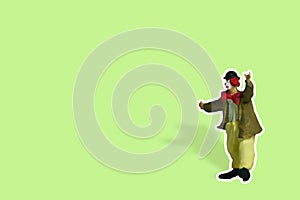 Miniature people toy figure photography. Full body of a clown wearing huge bowties sticker on green background